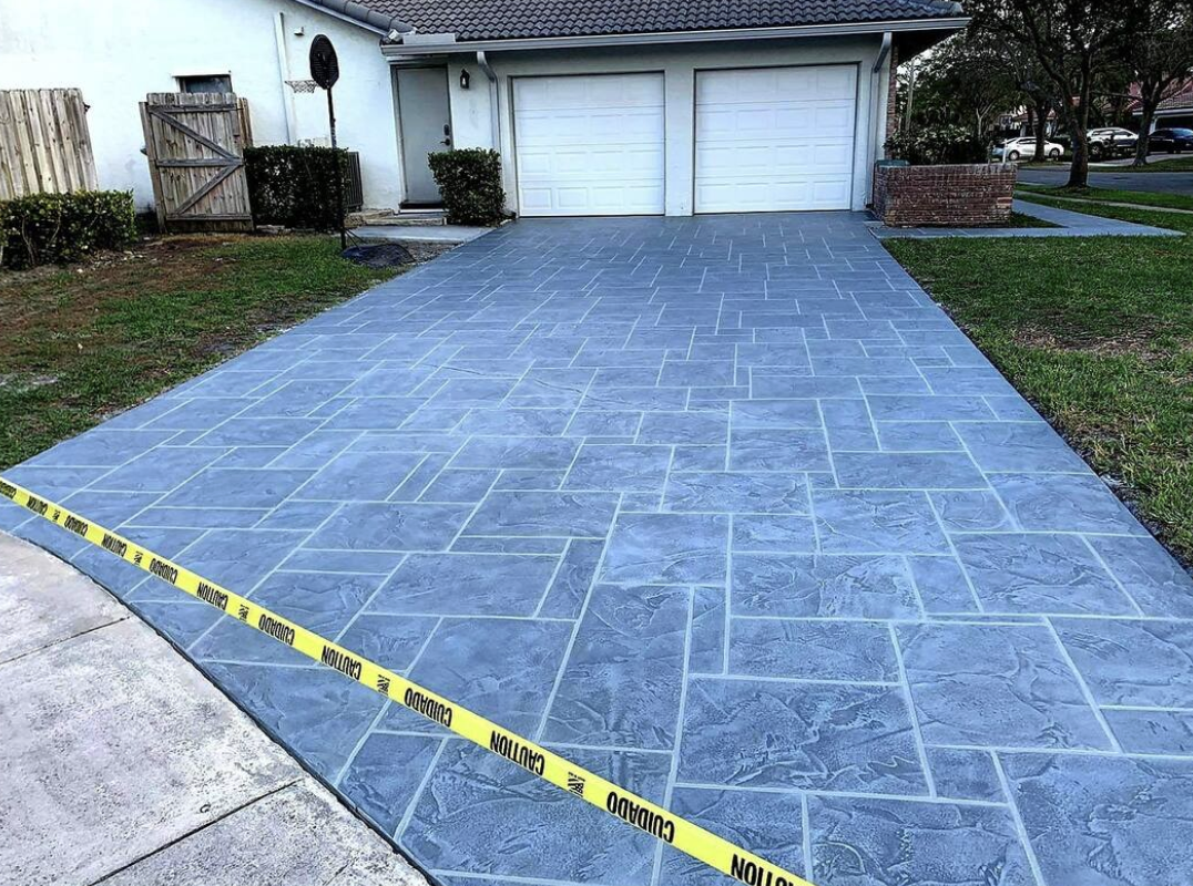 Blue-gray ashlar slate-pattern stamped concrete driveway in front of a two-car garage in Arlington, Jacksonville FL