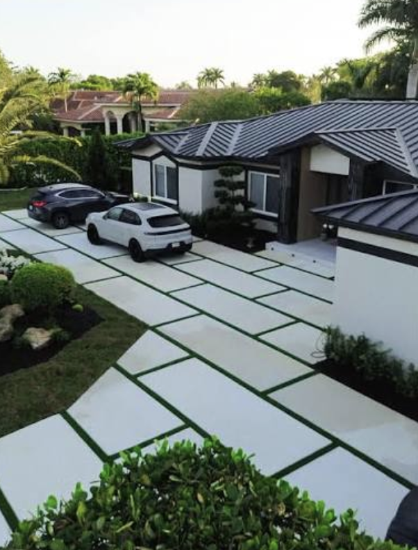 Modern driveway of large white concrete slabs separated by artificial turf strips at a home in Jacksonville Beach, FL