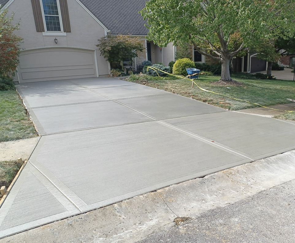 New broom-finish concrete driveway with smooth trowel borders and saw-cut control joints at a home in Mandarin, Jacksonville FL