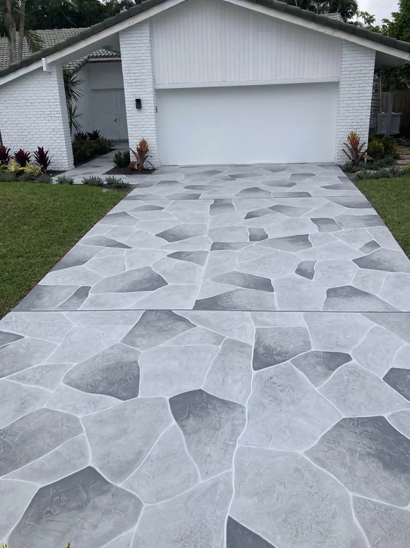 Gray two-tone flagstone-pattern stamped concrete driveway overlay leading to a white garage in San Marco, Jacksonville FL
