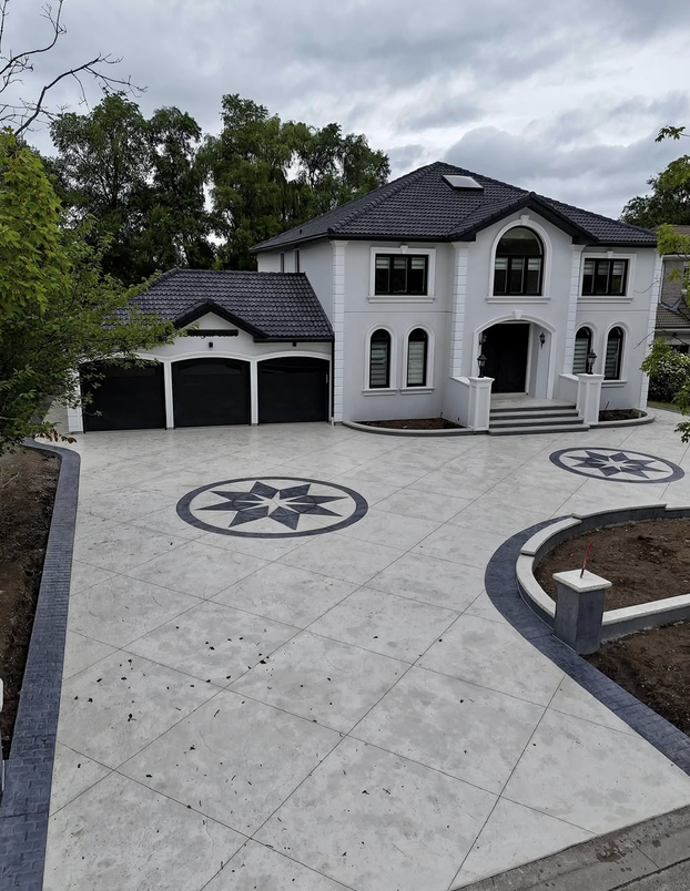 Large light-gray stamped concrete driveway with two compass-star medallions and charcoal borders at a home in Nocatee, FL